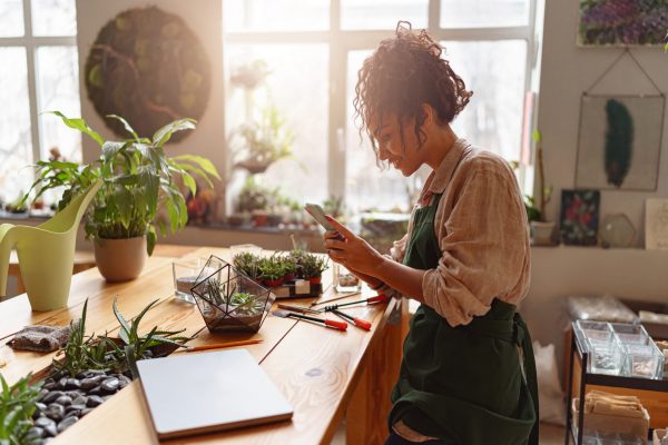 Self-employed florist looks at her smartphone.